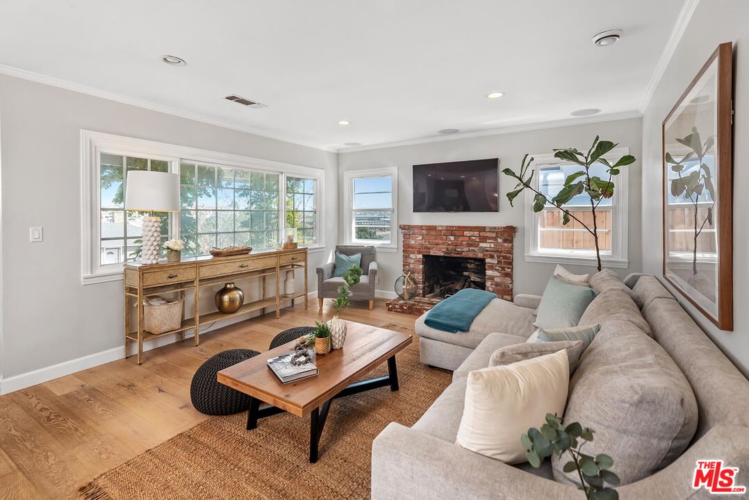 7517 Earldom Avenue Playa del Rey, CA 90293 - Photo 11 of 27 a living room with furniture a flat screen tv and a fireplace