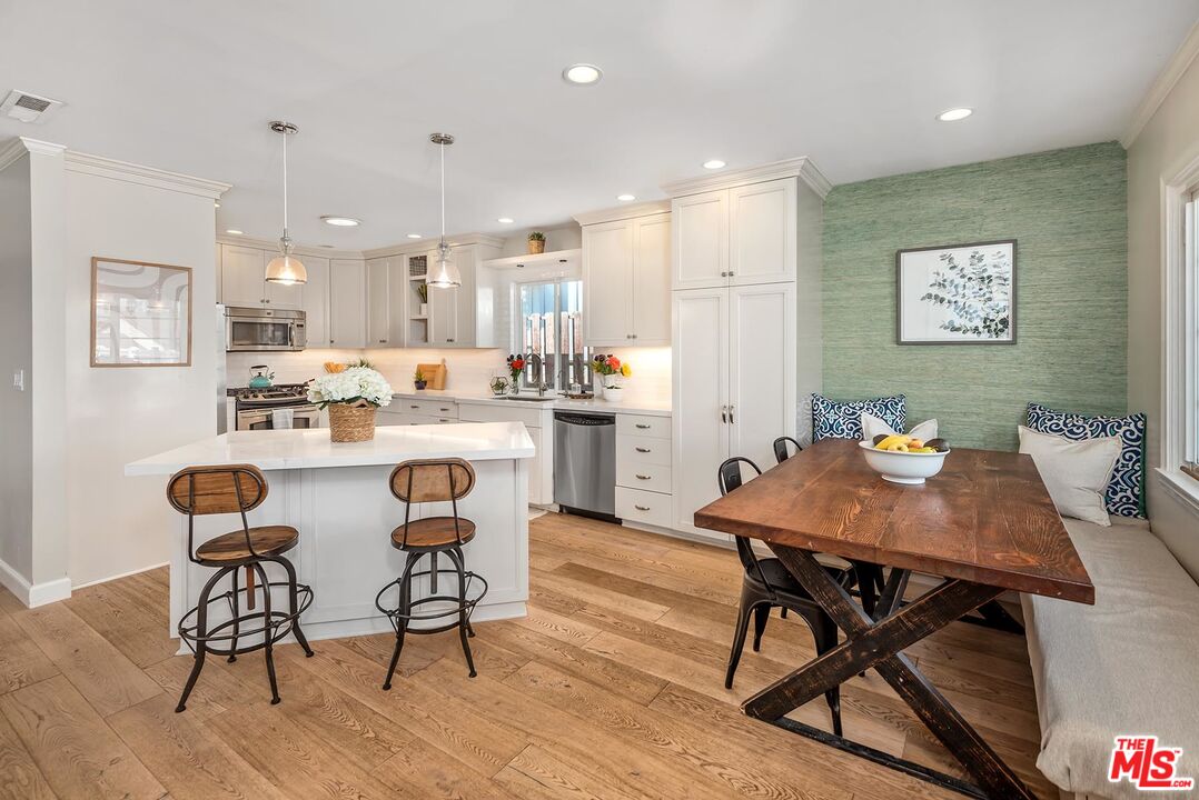 7517 Earldom Avenue Playa del Rey, CA 90293 - Photo 14 of 27 a dining room with stainless steel appliances kitchen island granite countertop a dining table chairs and a refrigerator