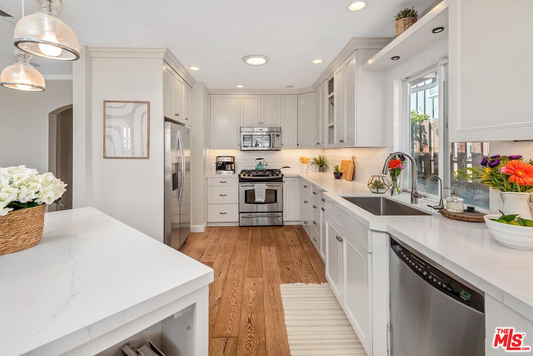 7517 Earldom Avenue Playa del Rey, CA 90293 - Photo 15 of 27 a kitchen that has a lot of cabinets a sink and appliances