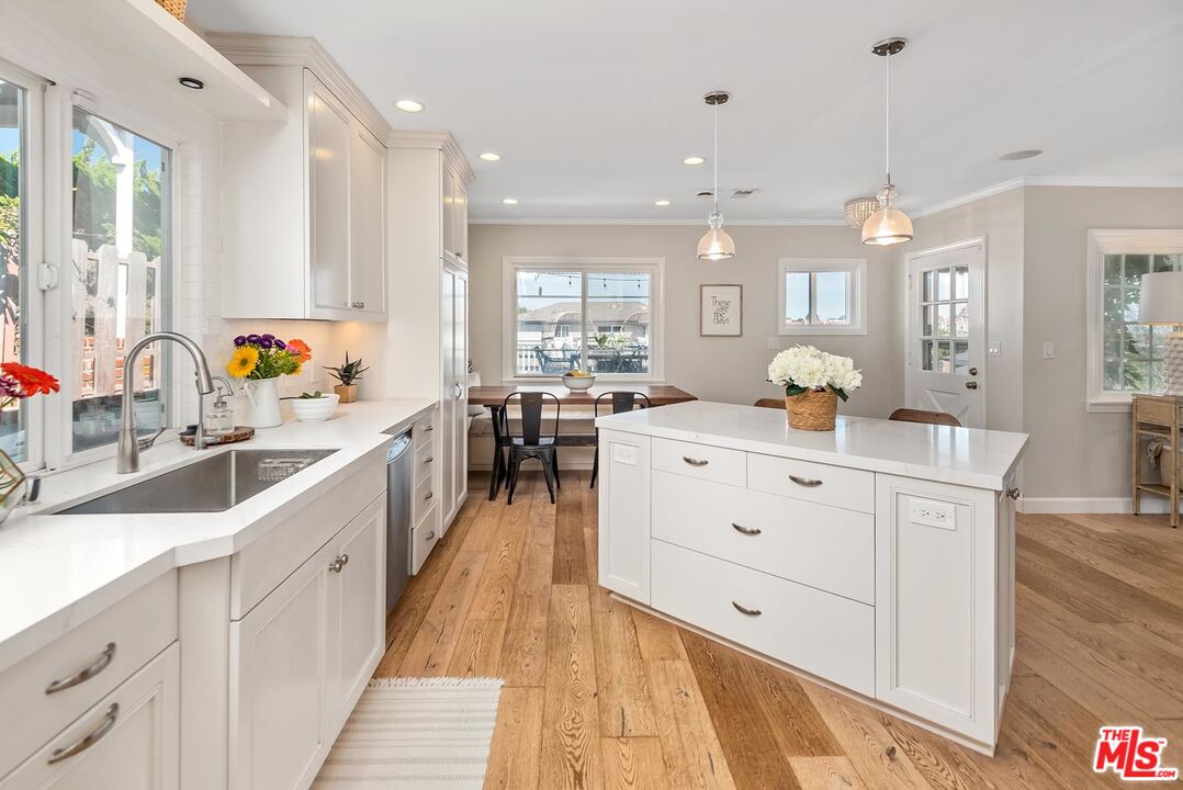 7517 Earldom Avenue Playa del Rey, CA 90293 - Photo 16 of 27 a large white kitchen with a large window a sink and stainless steel appliances