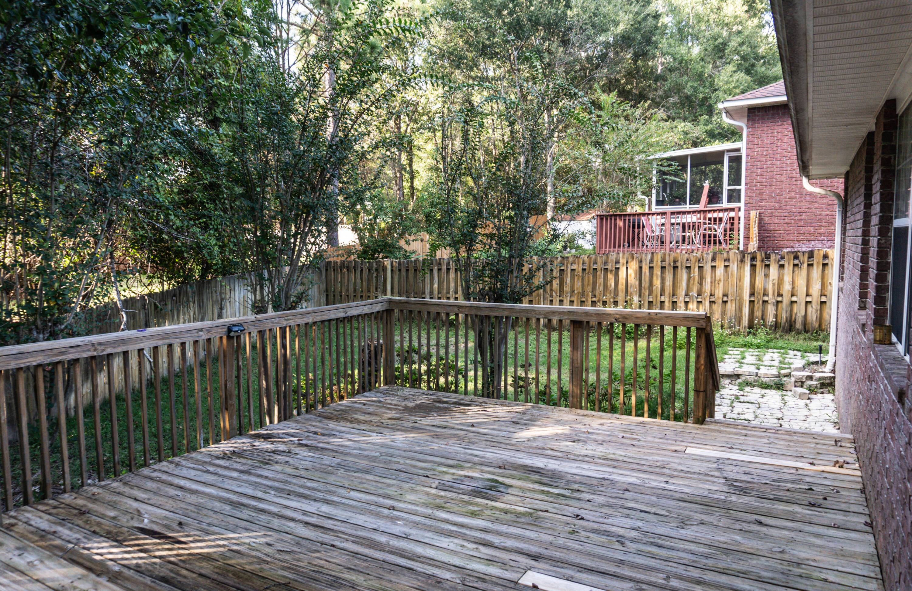 516 Vulpes Sanctuary Loop Crestview, FL 32536 - Photo 28 of 33 a view of a deck with wooden floor and fence
