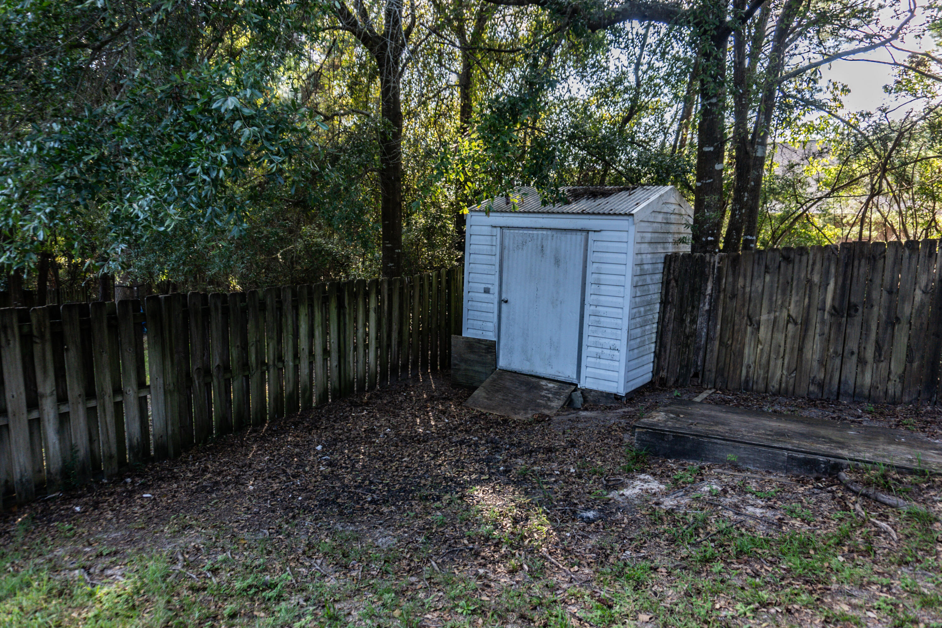 516 Vulpes Sanctuary Loop Crestview, FL 32536 - Photo 32 of 33 a wooden fence with trees in the background
