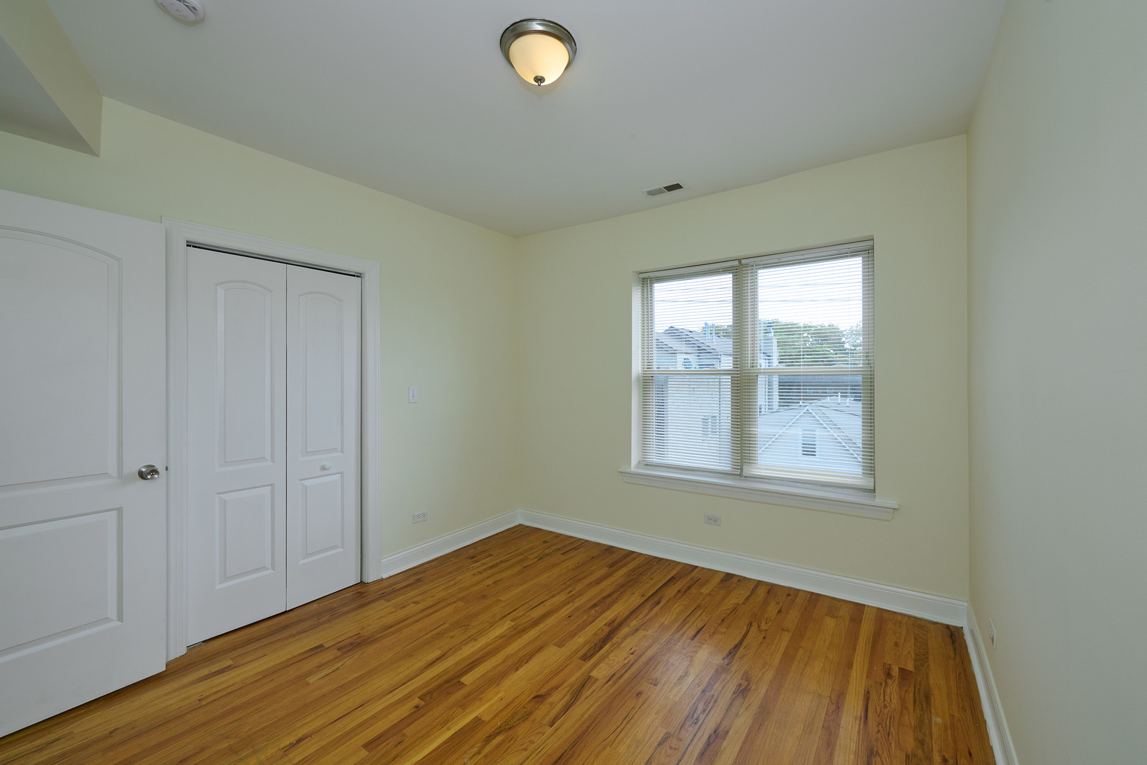 5014 North Harding Avenue, Unit 3S Chicago, IL 60625 - Photo 13 of 13 an empty room with wooden floor and windows