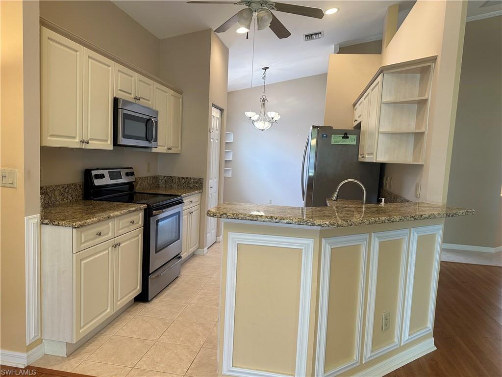 9003 Springview Loop Estero, FL 33928 - Photo 5 of 29 a kitchen with stainless steel appliances granite countertop a sink and a stove