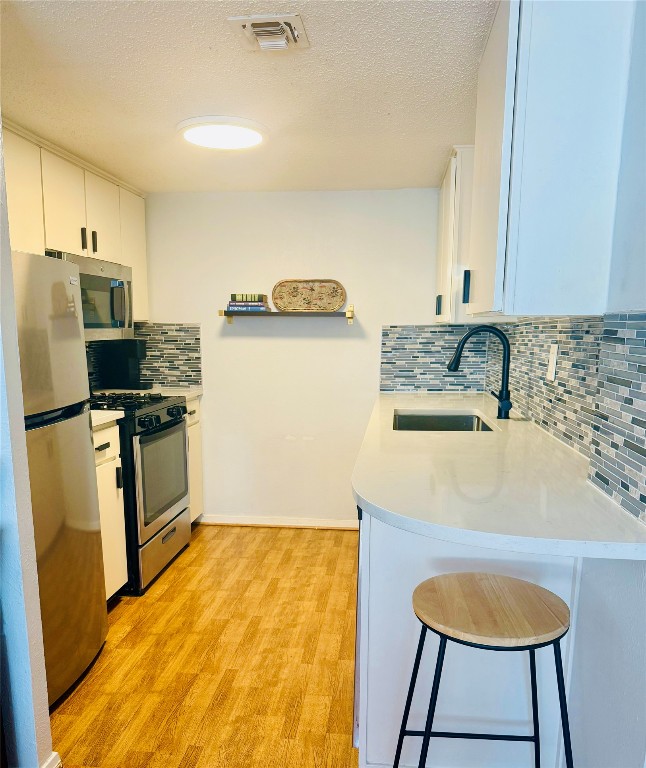 a kitchen with a sink a refrigerator and a stove