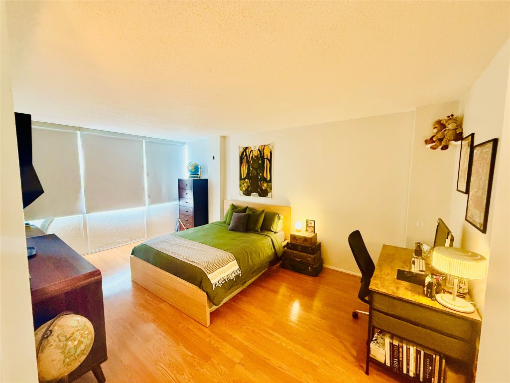 1800 Lavaca Street, Unit A305 Austin, TX 78701 - Photo 5 of 11 a bedroom with a bed and wooden floor