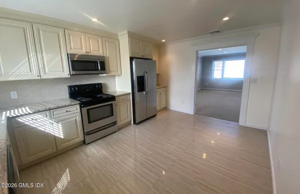 a kitchen with stainless steel appliances granite countertop a refrigerator and a stove top oven