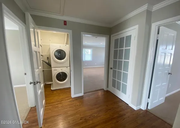 an entryway with wooden floor and washing machine