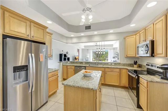 a kitchen with stainless steel appliances granite countertop a refrigerator and a stove top oven