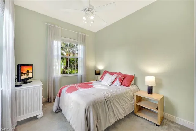 a bedroom with a bed and a flat tv screen on dresser
