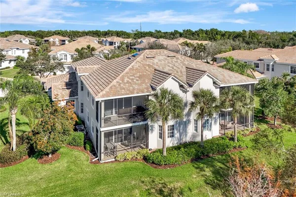 an aerial view of residential houses with outdoor space and trees all around