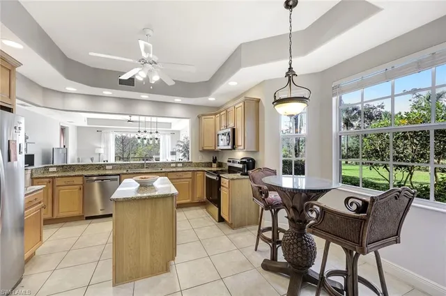 a kitchen with a dining table chairs cabinets and stainless steel appliances
