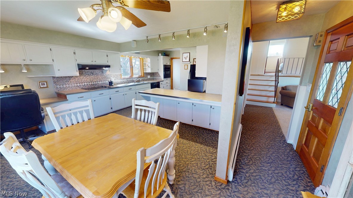 6904 Center Road Valley City, OH 44280 - Photo 7 of 36 Dining room with ceiling fan, a baseboard heating unit, and dark carpet