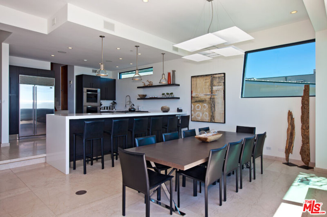 25250 Malibu Road Malibu, CA 90265 - Photo 12 of 31 a dining area with stainless steel appliances kitchen island a table and chairs