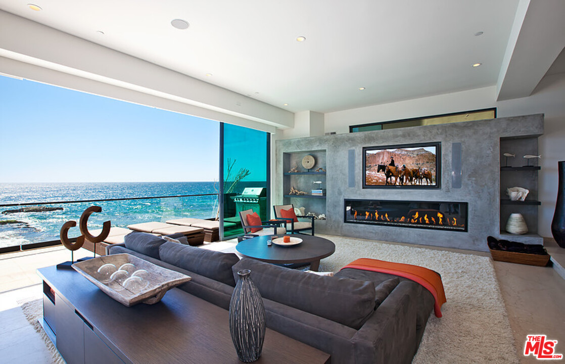 25250 Malibu Road Malibu, CA 90265 - Photo 2 of 31 a living room with furniture and a flat screen tv with kitchen view