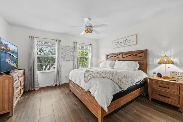 a bedroom with a bed and a flat tv screen on dresser