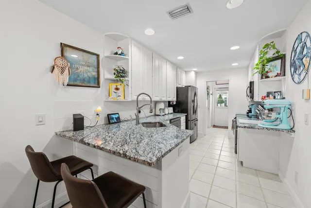 a kitchen with stainless steel appliances granite countertop a sink and a refrigerator