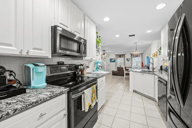 a kitchen with stainless steel appliances granite countertop a stove a sink and a microwave