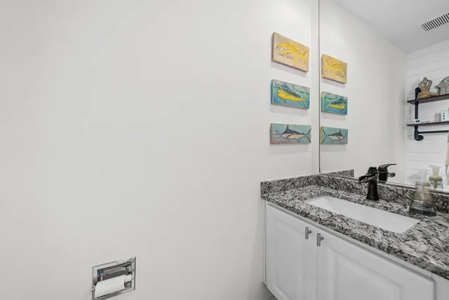 a bathroom with a granite countertop sink and a mirror