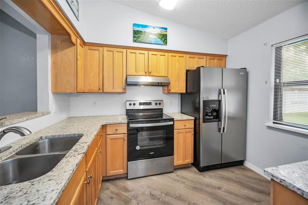 1890 Wolford Road, Unit 3 Clearwater, FL 33760 - Photo 16 of 47 a kitchen with stainless steel appliances granite countertop a refrigerator and a sink