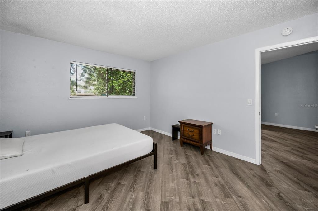 1890 Wolford Road, Unit 3 Clearwater, FL 33760 - Photo 25 of 47 a bedroom with a bed and a chair