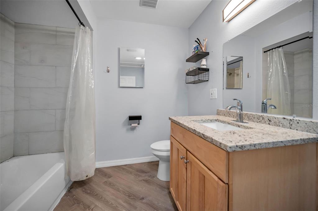 1890 Wolford Road, Unit 3 Clearwater, FL 33760 - Photo 26 of 47 a bathroom with a granite countertop sink a toilet and bathtub