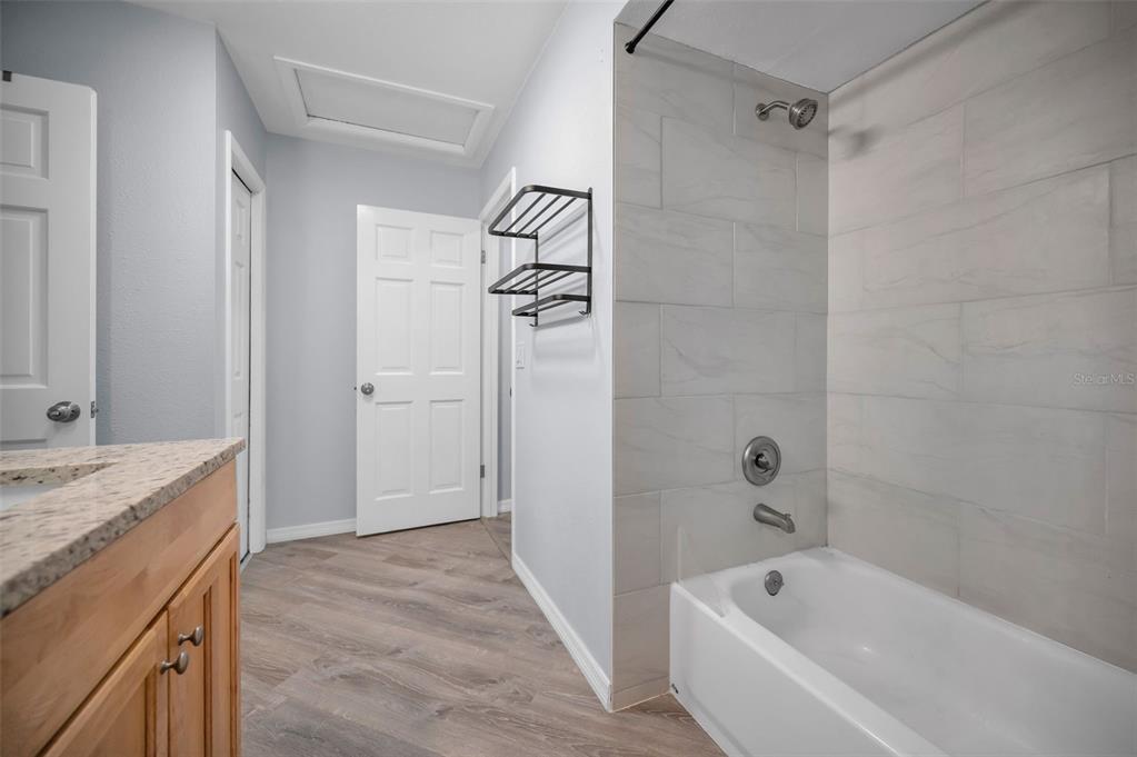 1890 Wolford Road, Unit 3 Clearwater, FL 33760 - Photo 27 of 47 a bathroom with a granite countertop bathtub sink vanity and shower
