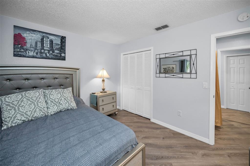 1890 Wolford Road, Unit 3 Clearwater, FL 33760 - Photo 30 of 47 a bedroom with a bed and a painting on the wall