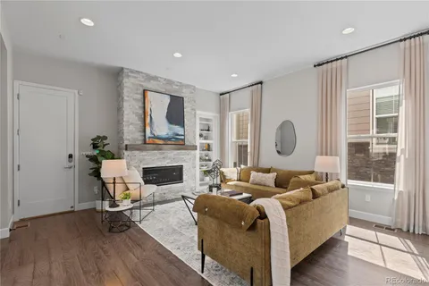 a living room with furniture a fireplace and a large window