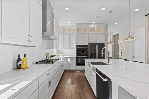 a large kitchen with stainless steel appliances lots of counter space and a sink
