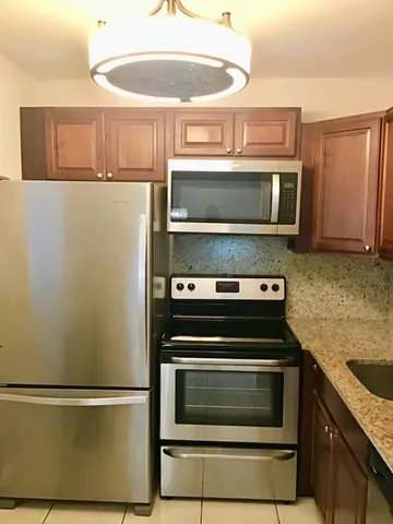 a kitchen with stainless steel appliances granite countertop white cabinets and a sink
