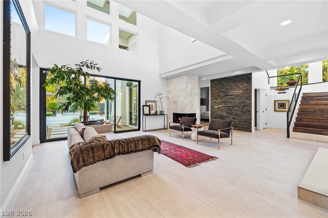 2000 Grouse Street Las Vegas, NV 89134 - Photo 5 of 89 A grand living space with soaring ceilings and a modern fireplace, offering seamless access to the outdoor oasis.