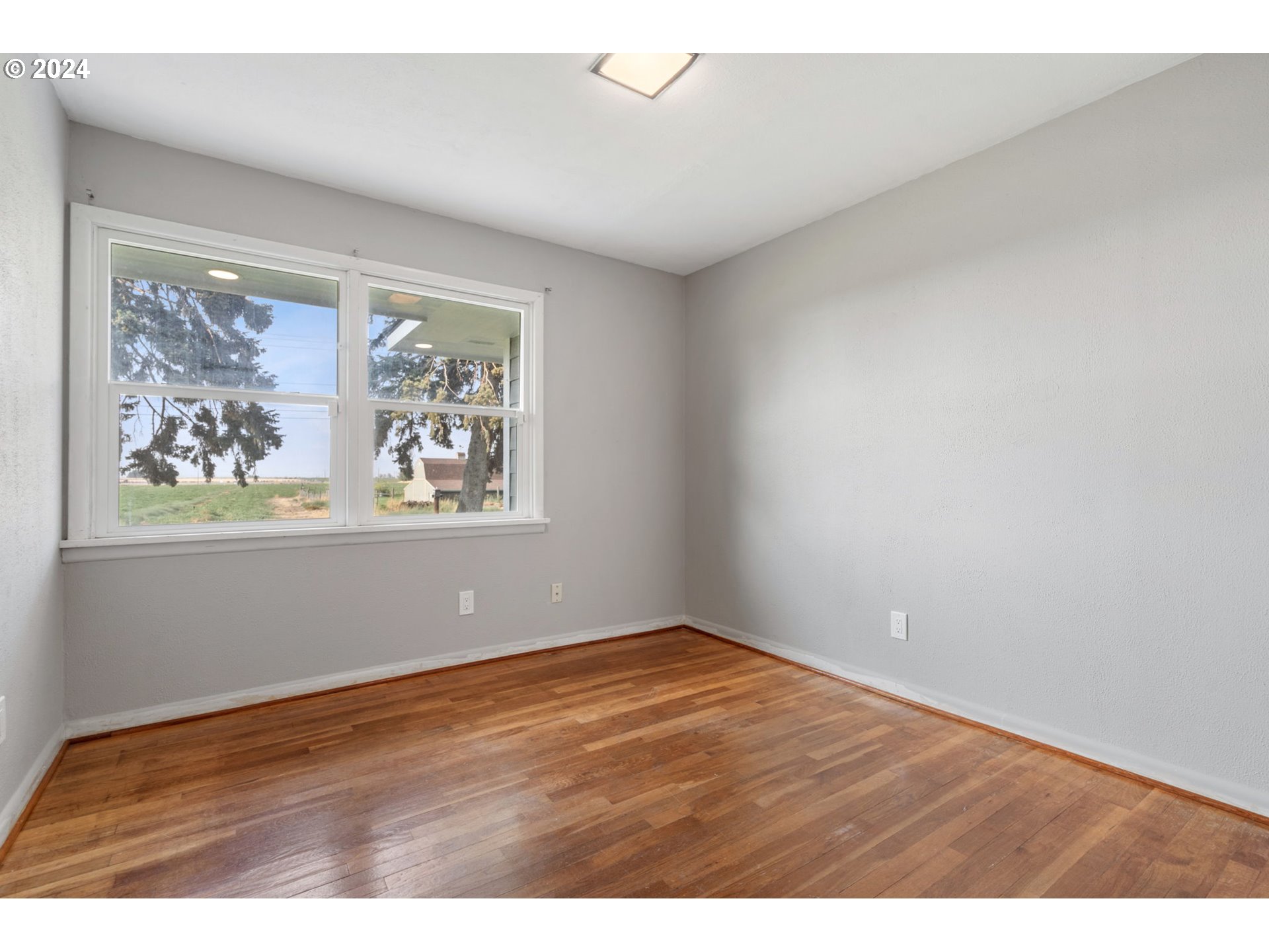 2150 East Airport Road Hermiston, OR 97838 - Photo 12 of 37 an empty room with wooden floor and window
