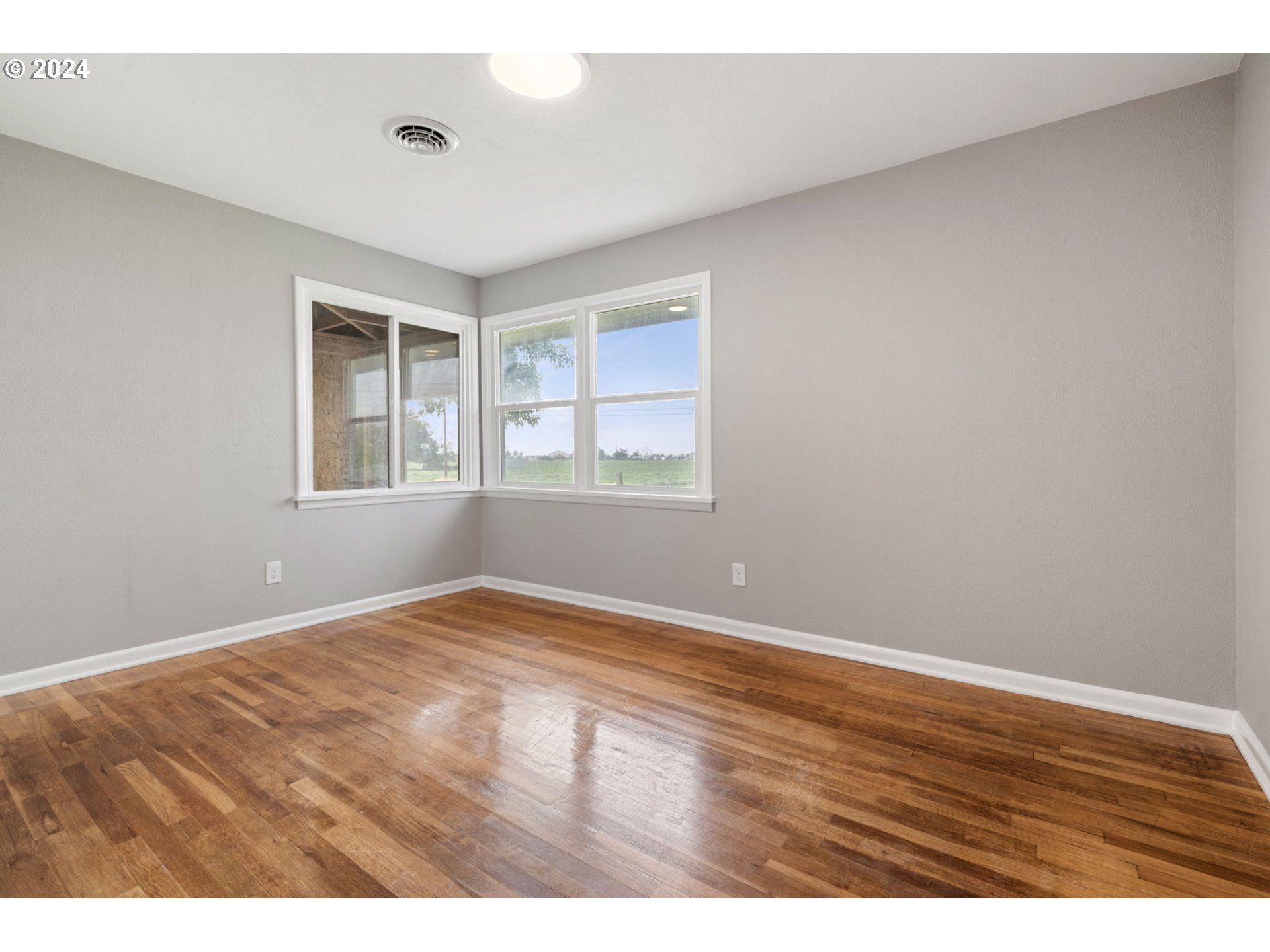 2150 East Airport Road Hermiston, OR 97838 - Photo 14 of 37 an empty room with wooden floor and windows