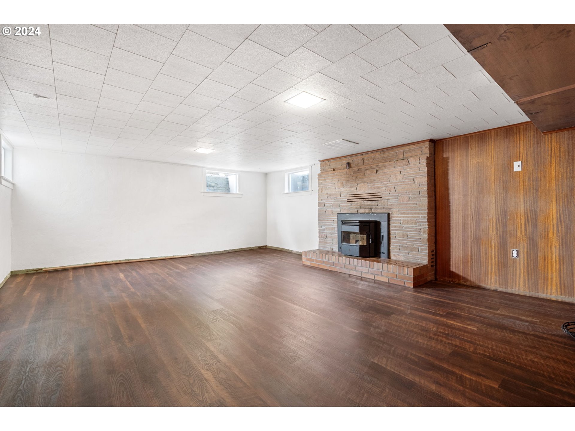 2150 East Airport Road Hermiston, OR 97838 - Photo 18 of 37 a view of empty room with wooden floor and fireplace