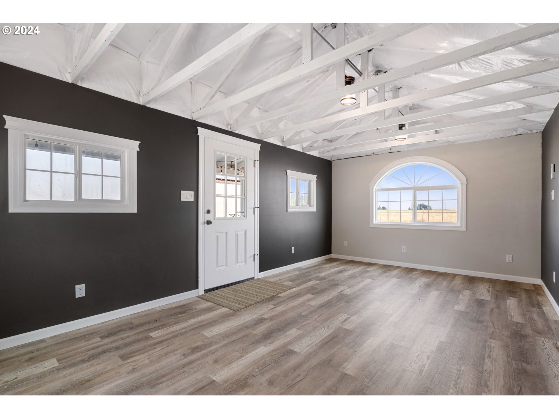 2150 East Airport Road Hermiston, OR 97838 - Photo 26 of 37 a view of an empty room with a window and wooden floor