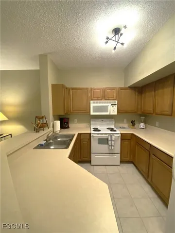 a large white kitchen with a stove a sink and dishwasher