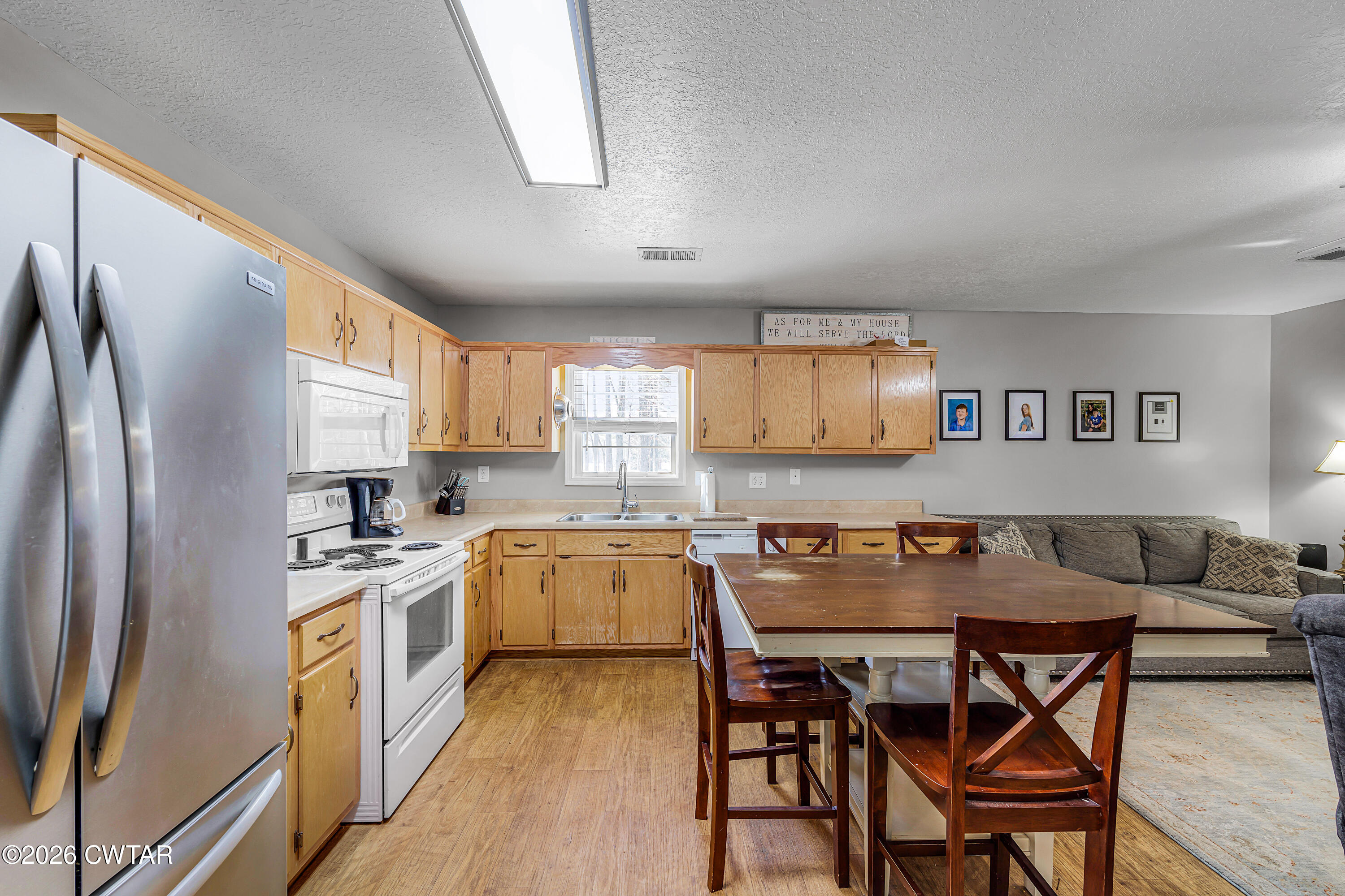 67 Robert Crocker Road Bradford, TN 38316 - Photo 5 of 20 a kitchen with stainless steel appliances granite countertop a stove a refrigerator a sink a dining table and chairs with wooden floor