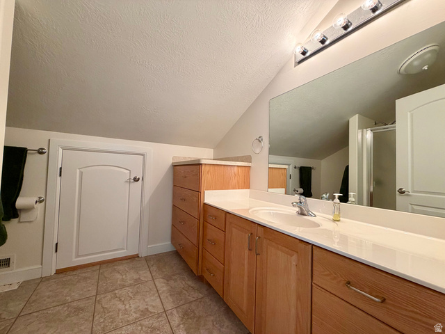 1133 Paris Canyon Road Paris, ID 83261 - Photo 27 of 75 Bathroom featuring a light wood-finish vanity with a single sink and white countertop, extensive mirror, and tiled flooring