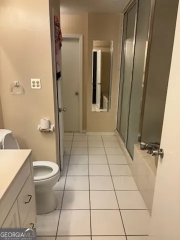 a bathroom with a granite countertop toilet and a shower