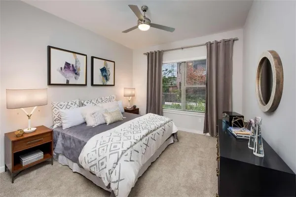 a bedroom with bed and a painting on the wall