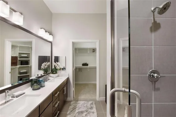 a bathroom with a double vanity sink a mirror and shower