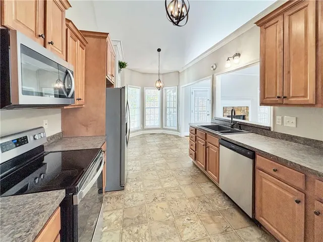 a kitchen with granite countertop wooden cabinets and stainless steel appliances