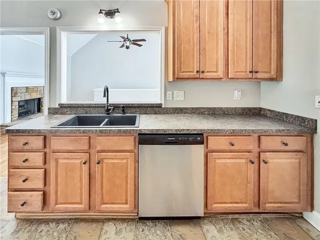 an empty room with wooden floor chandelier fan and windows
