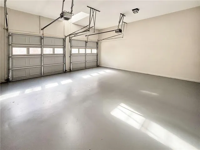 a backyard of a house with large trees and wooden fence