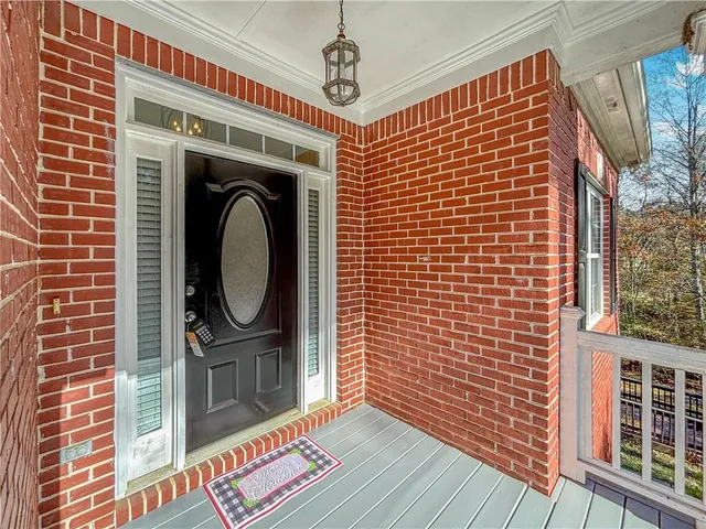 a view of a livingroom with a fireplace a ceiling fan and windows