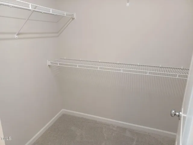 a large white bed sitting in a bedroom next to a window