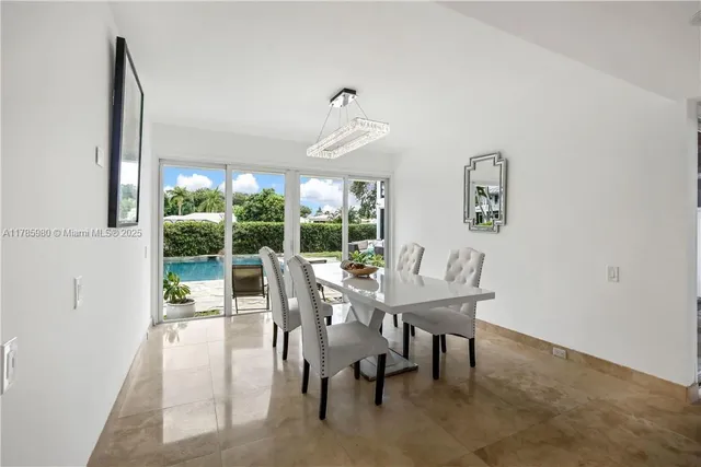 a dining room with furniture a chandelier and a rug