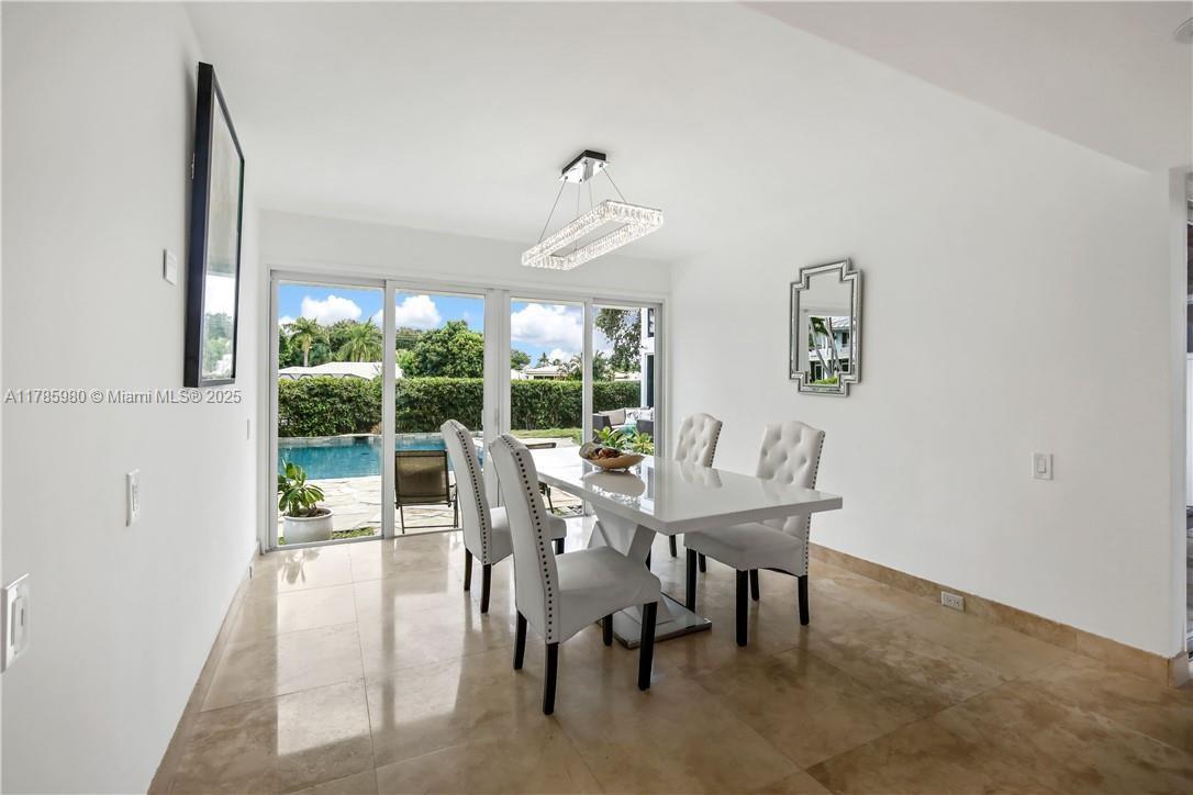 4050 Northeast 25th Avenue Lighthouse Point, FL 33064 - Photo 11 of 35 a dining room with furniture a chandelier and a rug