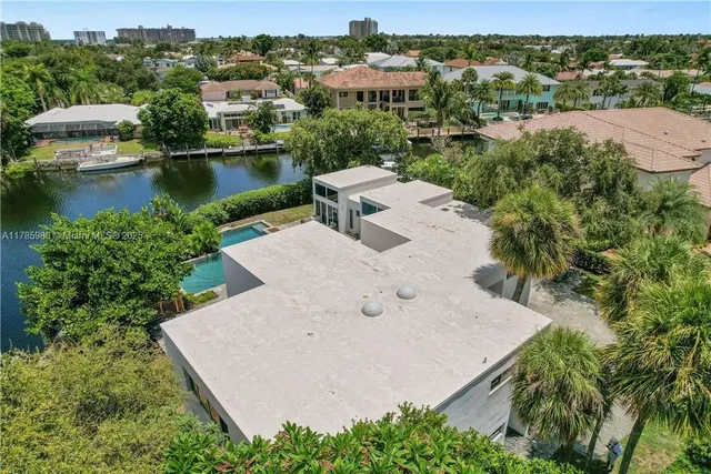 an aerial view of a house with a yard and lake view